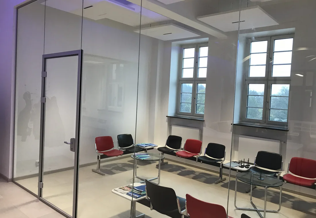 Verglaster Besprechungsraum mit transparenter Tür und dunklen Profilen
